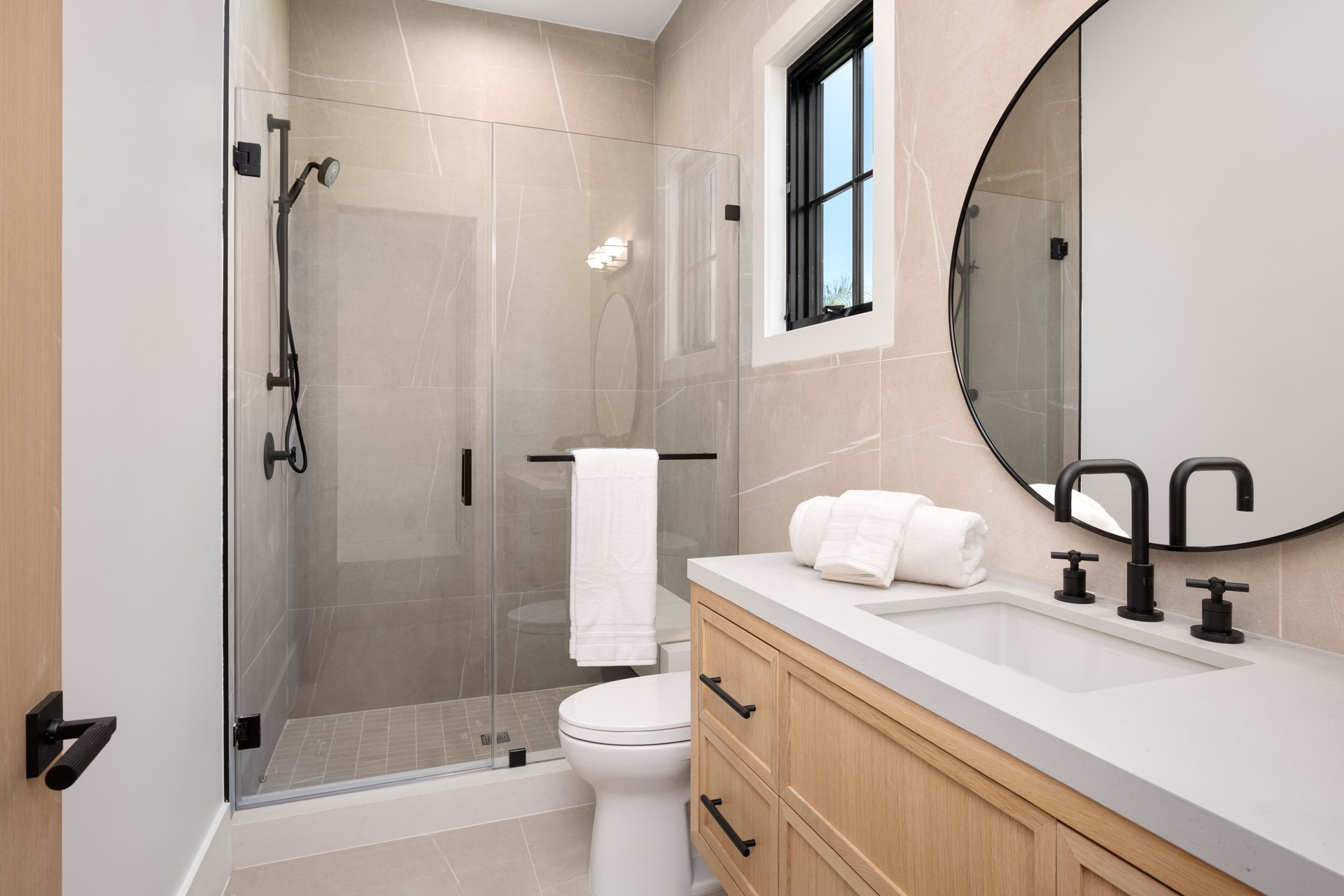 Modern bathroom with glass shower and wooden vanity